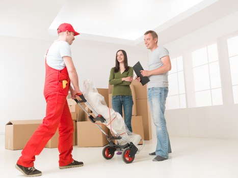 House movers carrying furniture in a Tooting home