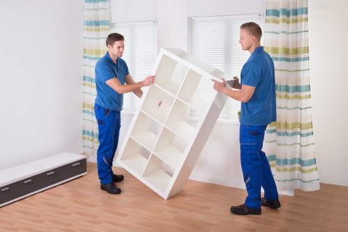 Two workers using safe lifting techniques with furniture